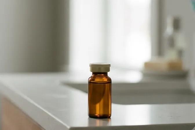Amber testosterone vial on a clean bathroom counter in soft light