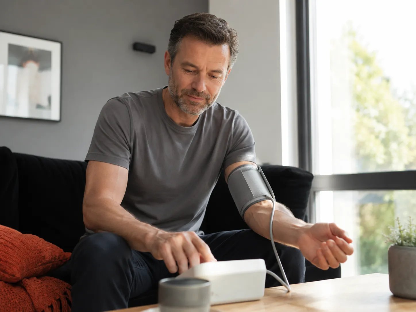 Man checking his blood pressure at home while considering TRT and blood pressure